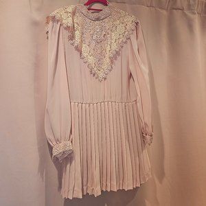 Pink pleated dress with a lace bib